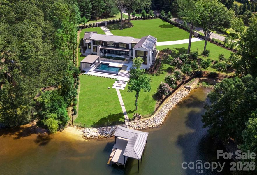 Aerial view of the property featuring the lakefront and dock. Aerial view of the property featuring the lakefront and dock.