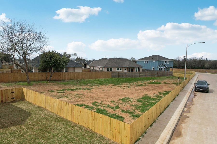 View of large side yard with fence