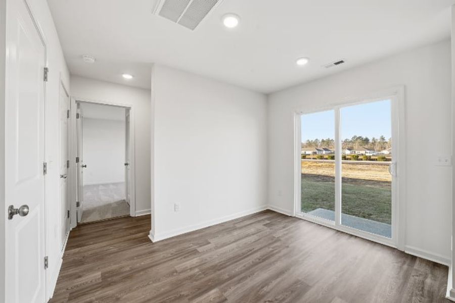 A room with a wood floor and a window with a view of a city. A room with a wood floor and a window with a view of a city.