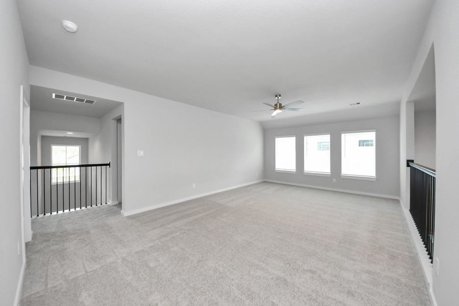 Come upstairs and enjoy a day of leisure in this fabulous game room! This is the perfect hangout spot or adult game room! Features plush carpet, high ceilings, custom paint and windows for plenty of natural light. Sample photo of completed home with similar floor plan. Actual colors and selections may vary. Come upstairs and enjoy a day of leisure in this fabulous game room! This is the perfect hangout spot or adult game room! Features plush carpet, high ceilings, custom paint and windows for plenty of natural light. Sample photo of completed home with similar floor plan. Actual colors and selections may vary.