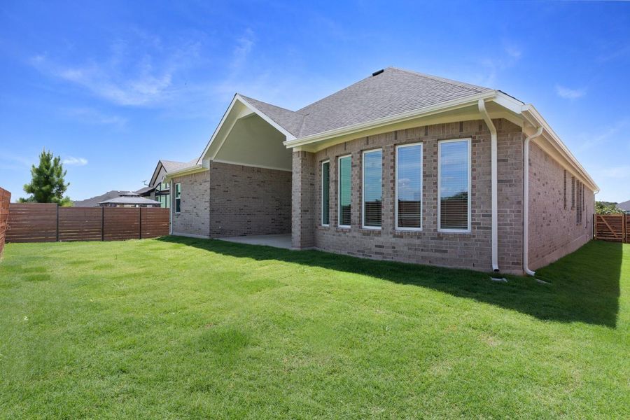 A pristine, well-maintained lawn embraces this brick residence, providing ample space for outdoor enjoyment.