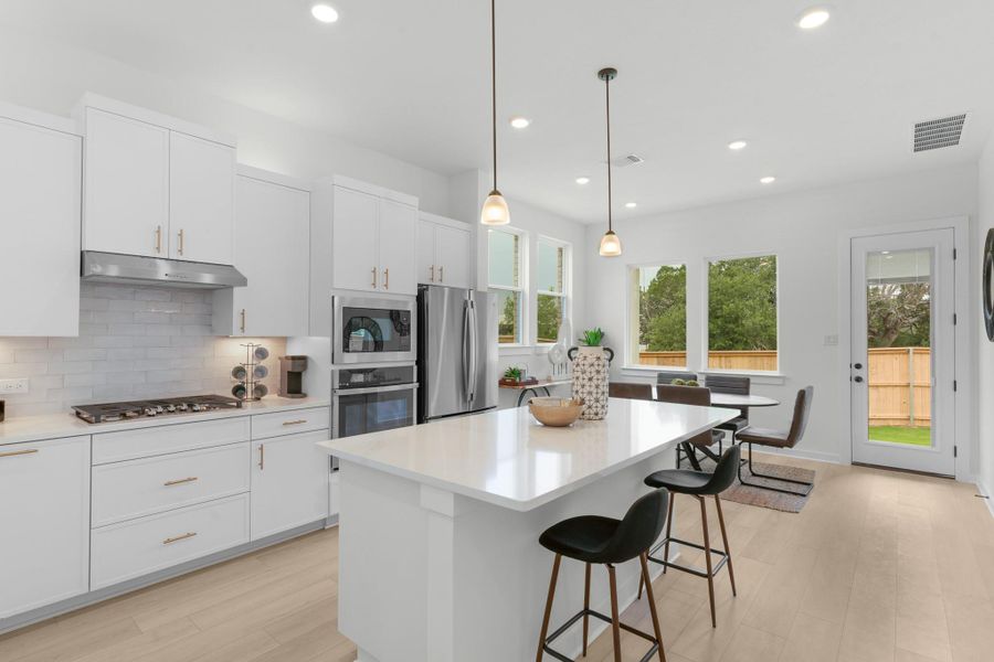 Kitchen featuring appliances with stainless steel finishes, under cabinet range hood, healthy amount of natural light, tasteful backsplash, and recessed lighting