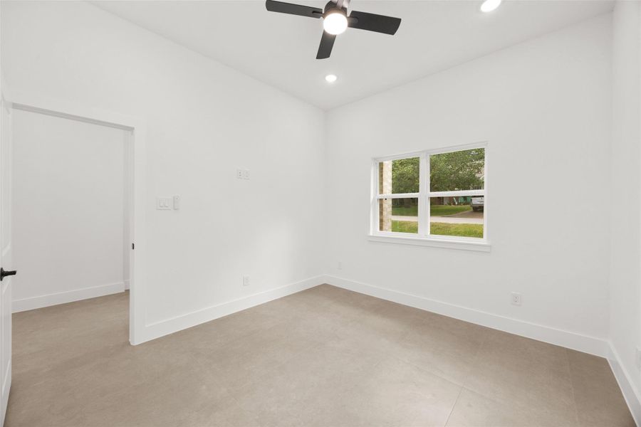 Another view of the Office/Study featuring high ceilings, large window, and modern ceiling fan.