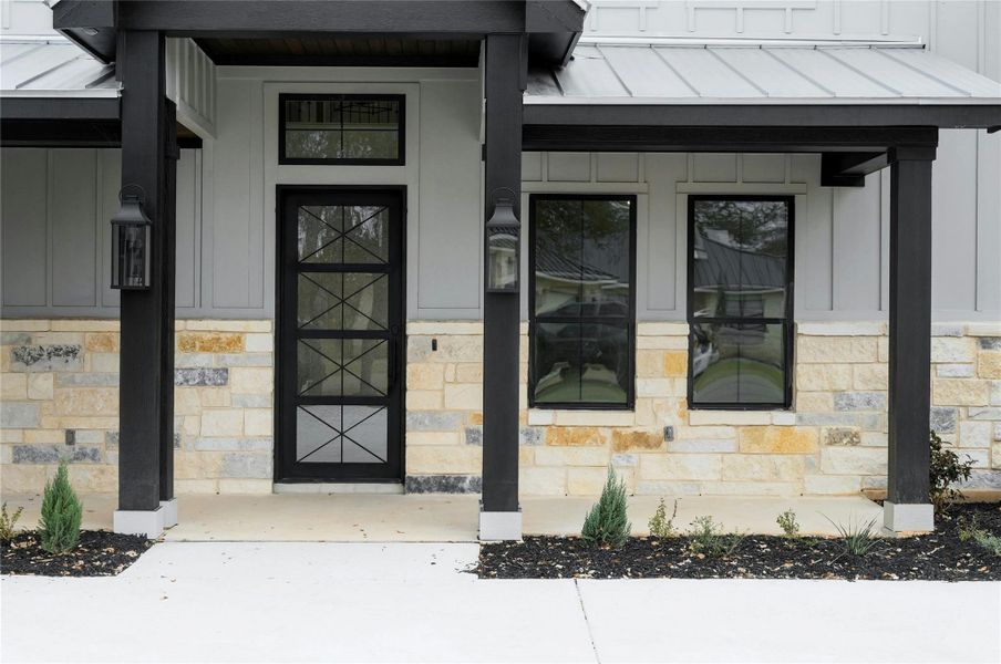 View of exterior entry featuring stone siding and board and batten siding