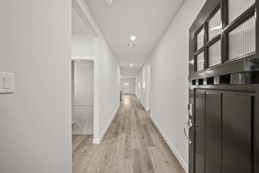 A hallway with black cabinets.