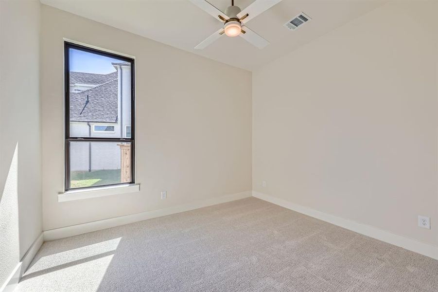 Spare room with ceiling fan and light colored carpet