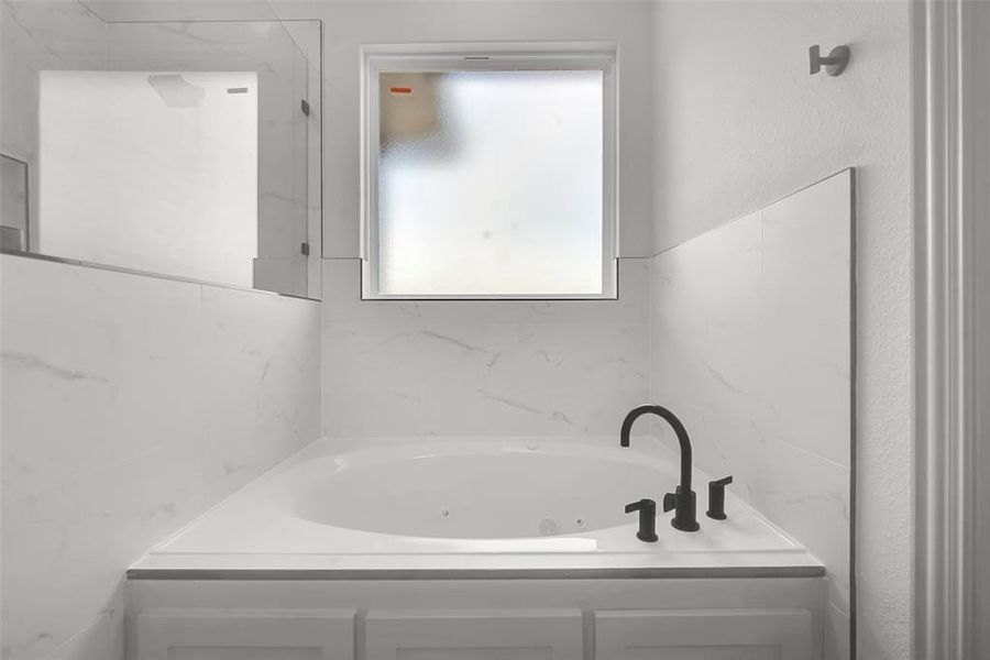 Bathroom featuring a tub with jets Bathroom featuring a tub with jets