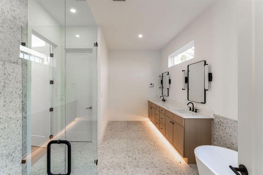 Bathroom featuring vanity, separate shower and tub, and tile walls