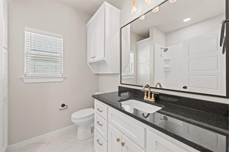 Bathroom with vanity, light marble finish floors, and a shower