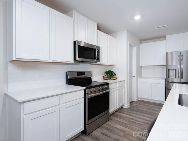 Kitchen features stainless steel appliances and walk-in pantry.