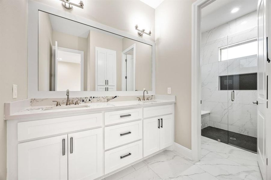 Bathroom with an enclosed shower, vanity, and tile patterned floors