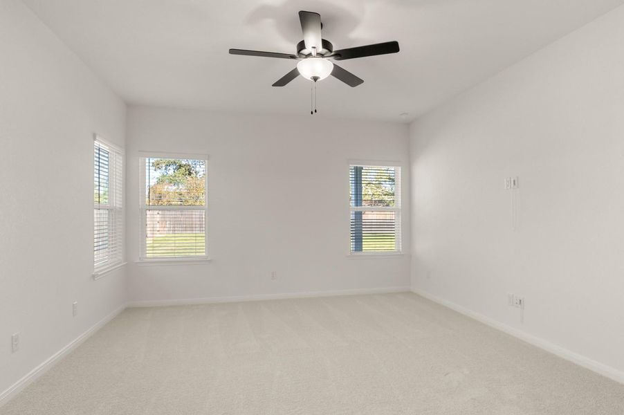 Unfurnished room featuring light colored carpet and a ceiling fan Unfurnished room featuring light colored carpet and a ceiling fan