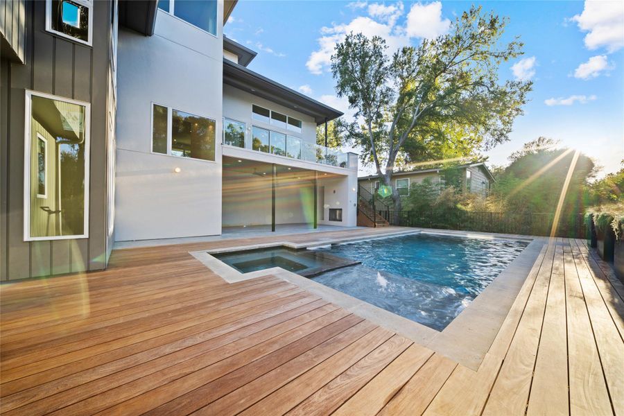 View of pool with stairway, a patio area, a balcony, and a pool with connected hot tub