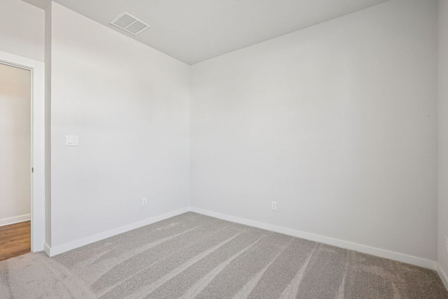 A room with a carpet and a rug.