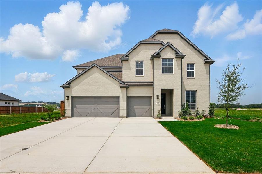 Traditional home featuring concrete driveway, brick siding, and an attached garage