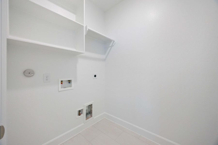 A clean, functional laundry zone with upper shelving and plenty of wall space—located just steps from all three upstairs bedrooms.