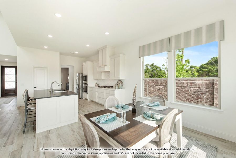 Open kitchen and dining area with white cabinets, center island, stainless appliances, and large windows