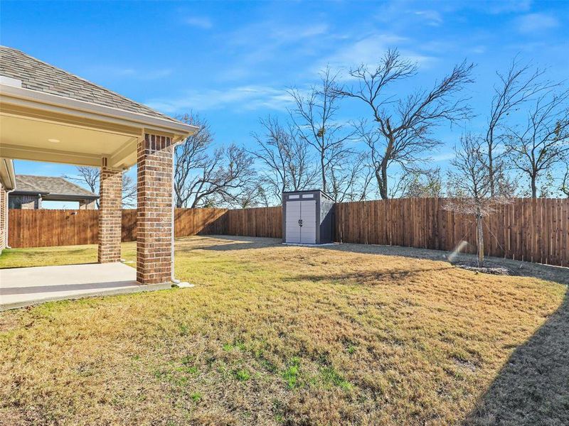 View of yard with a storage unit and a patio area