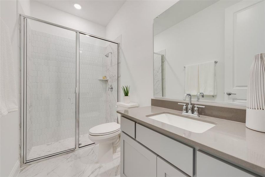 Bathroom featuring vanity, toilet, and a shower with shower door