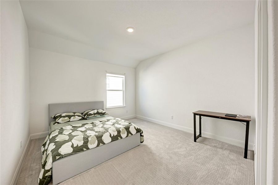 Spacious room featuring light-colored walls, recessed ceiling lighting, and a window providing natural light