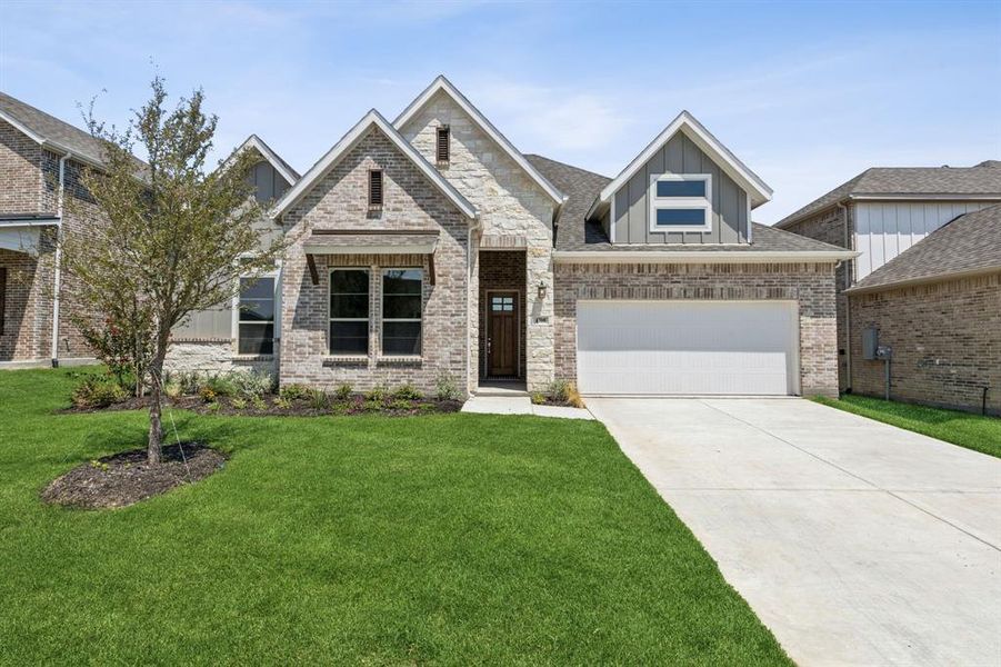 View of front of home featuring a garage and a front lawn