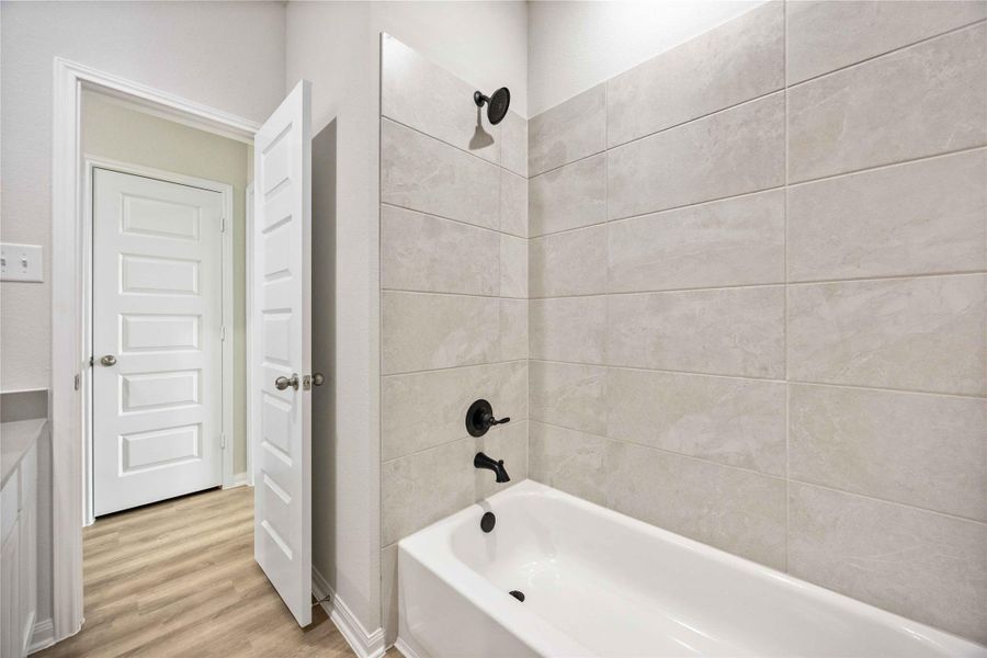 The tiled shower and modern black hardware make this secondary bathroom feel even more luxurious for your family and guests. The tiled shower and modern black hardware make this secondary bathroom feel even more luxurious for your family and guests.