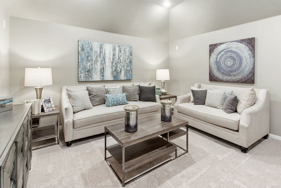 Living room with two cream sofas, wood coffee table, and abstract wall art on gray walls