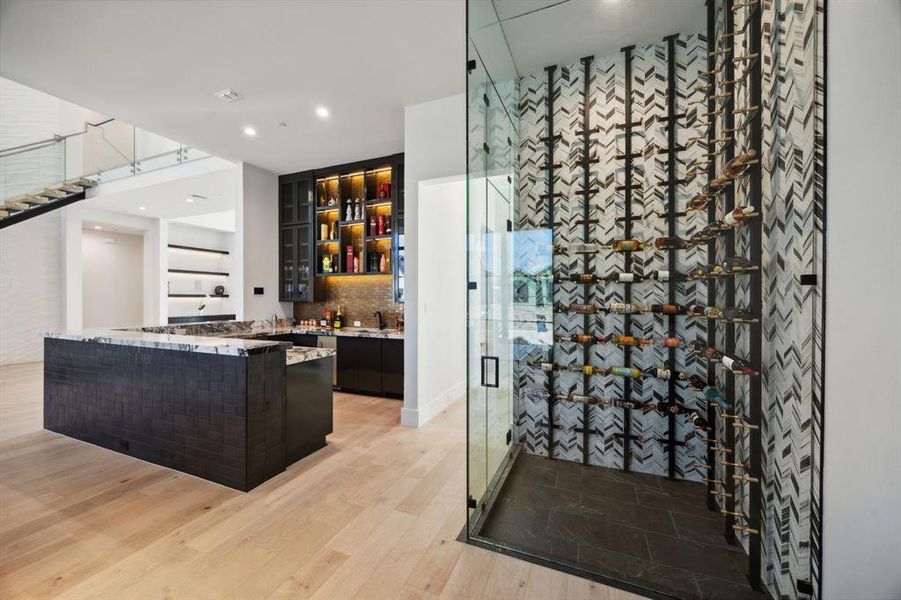 Wine room with sink and light hardwood / wood-style floors