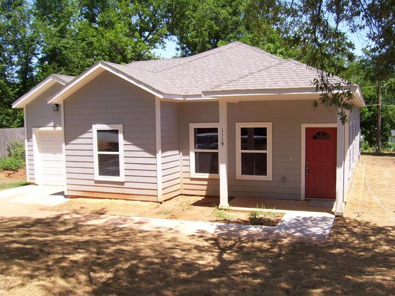 View of front facade featuring roof with shingles and a garage View of front facade featuring roof with shingles and a garage