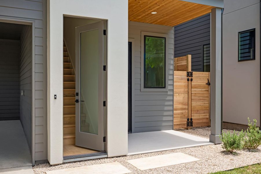 A modern facade with inviting entry, featuring sleek siding and an intimate patio space.