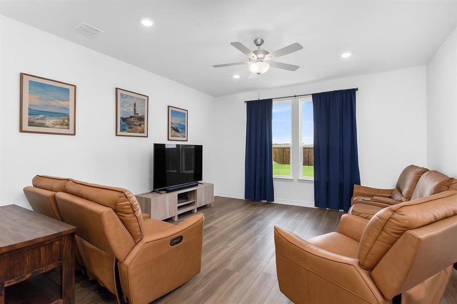 Living room with wood finished floors, recessed lighting, and ceiling fan
