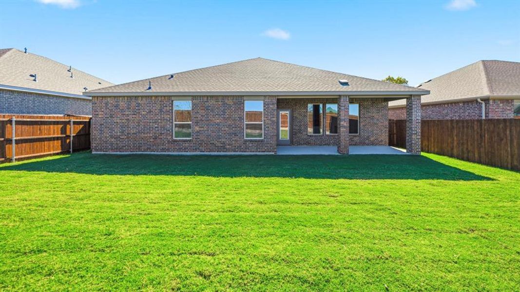 Back of property with brick siding, a fenced backyard, a patio, and a shingled roof Back of property with brick siding, a fenced backyard, a patio, and a shingled roof