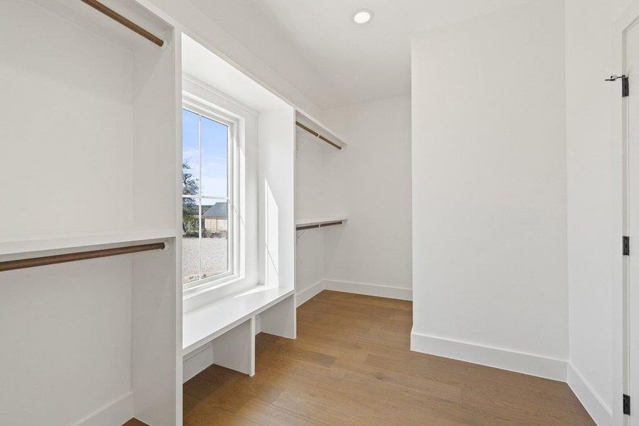 Walk in closet with light wood-type flooring
