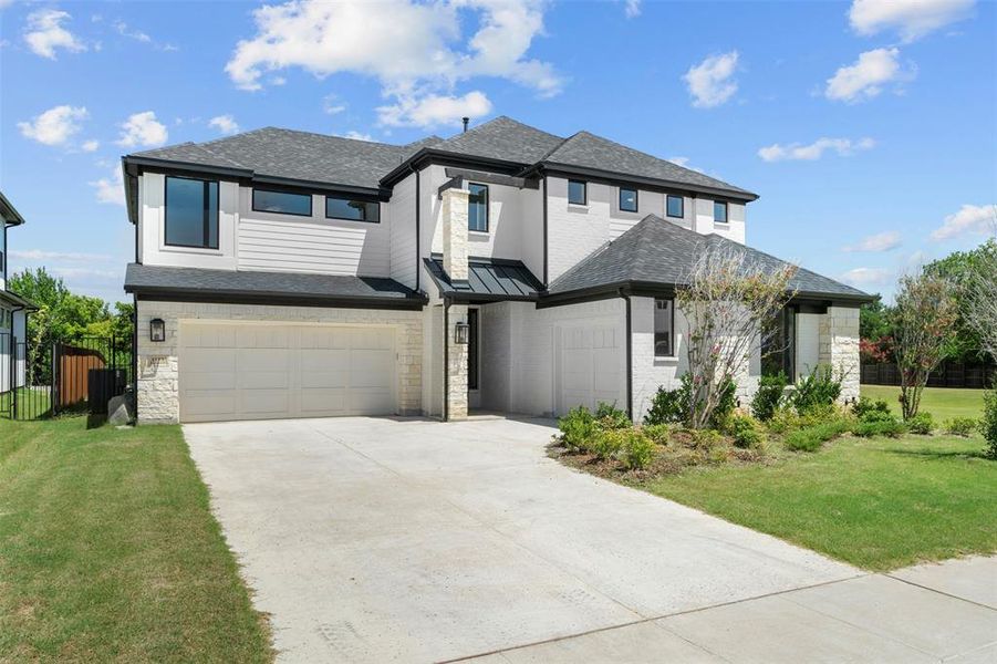 Prairie-style home featuring roof with shingles, driveway, stone siding, and an attached garage