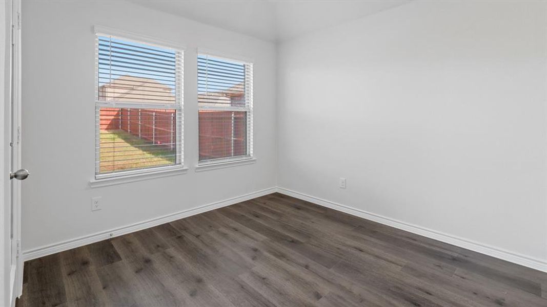 Empty room with dark wood-style floors and baseboards