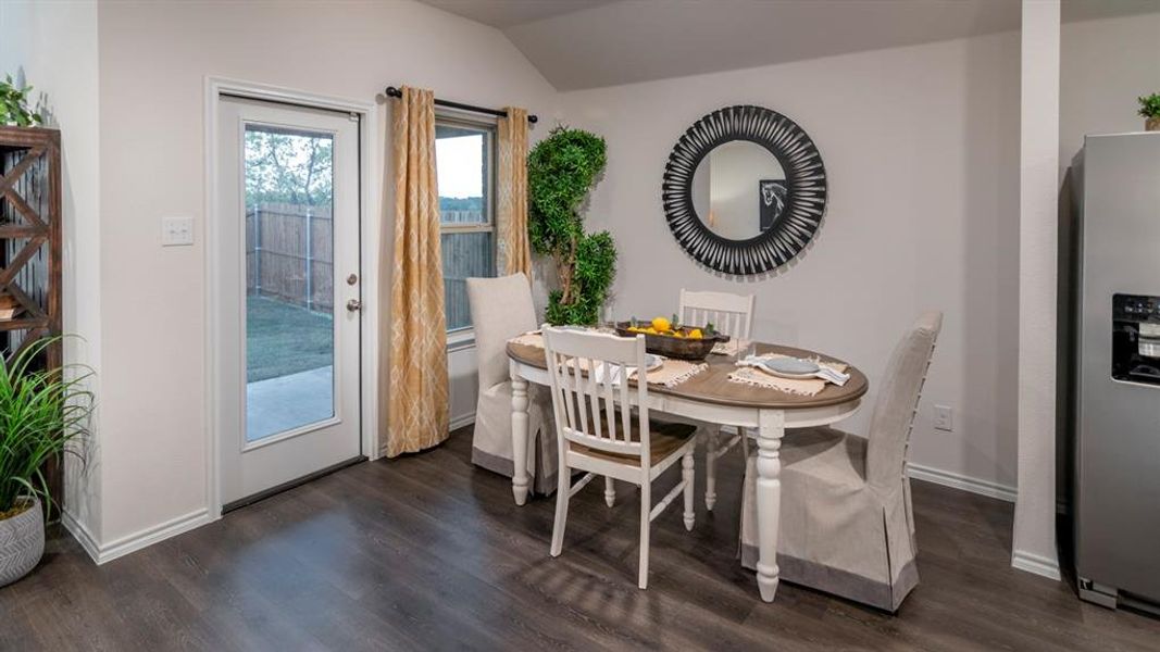 Dining space with vaulted ceiling and dark wood finished floors