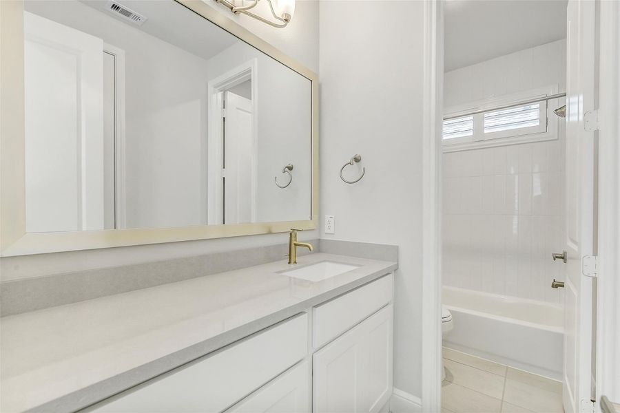 The second bathroom with tile flooring and marble vanity countertop The second bathroom with tile flooring and marble vanity countertop