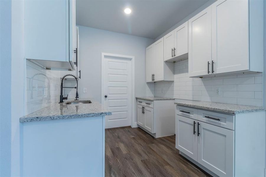 Kitchen with white cabinets, sink, and dark hardwood / wood-style floors