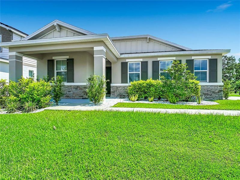 Front exterior of a new home in Seasons at Big Sky, Kissimmee, FL, highlighting curb appeal (Image 26).