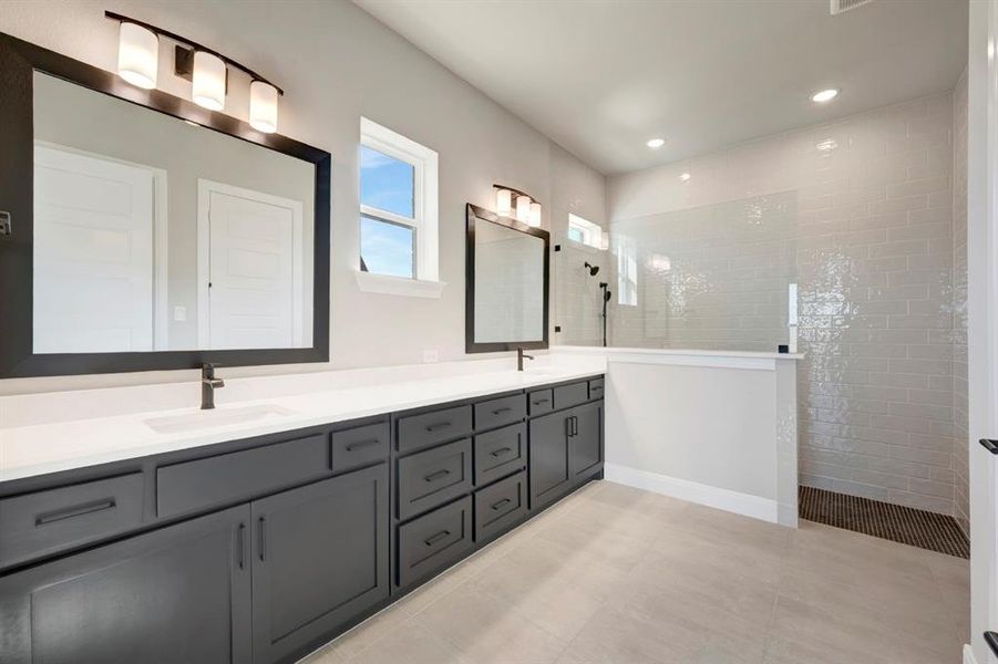 Bathroom with double vanity, walk in shower, recessed lighting, and light tile patterned flooring Bathroom with double vanity, walk in shower, recessed lighting, and light tile patterned flooring