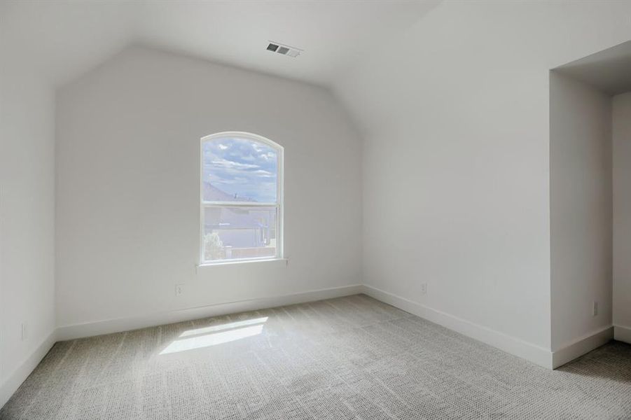 Room with vaulted ceiling, arched window, light gray carpeting, crisp white walls, and white baseboards Room with vaulted ceiling, arched window, light gray carpeting, crisp white walls, and white baseboards