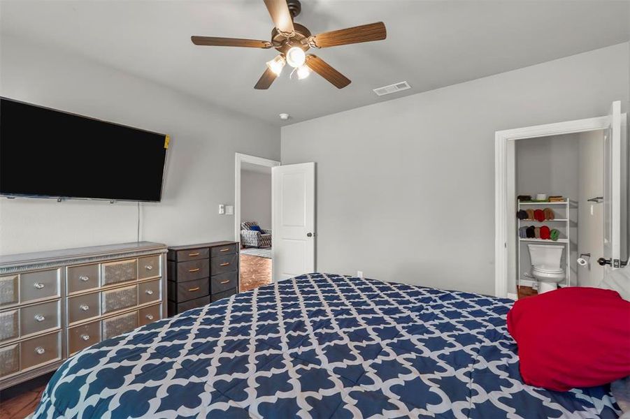 Primary Bedroom with ensuite bathroom, and ceiling fan