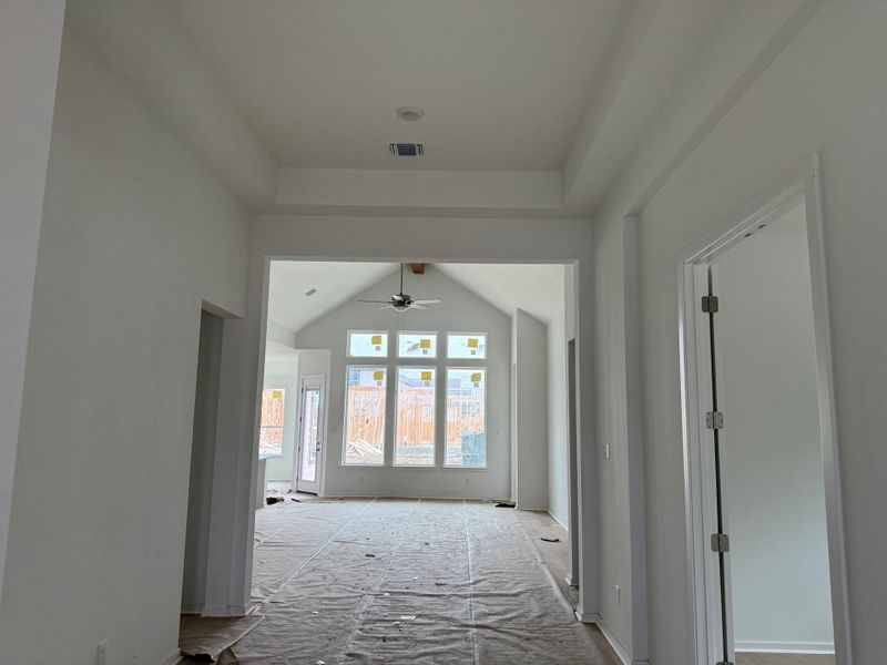 Corridor featuring lofted ceiling and baseboards Corridor featuring lofted ceiling and baseboards