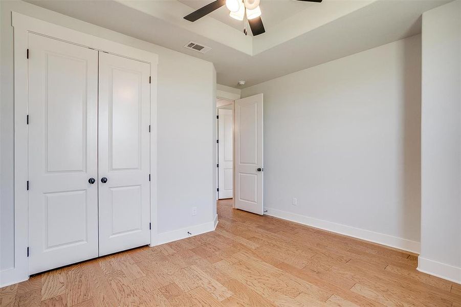 Unfurnished bedroom with light hardwood / wood-style flooring, a closet, and ceiling fan