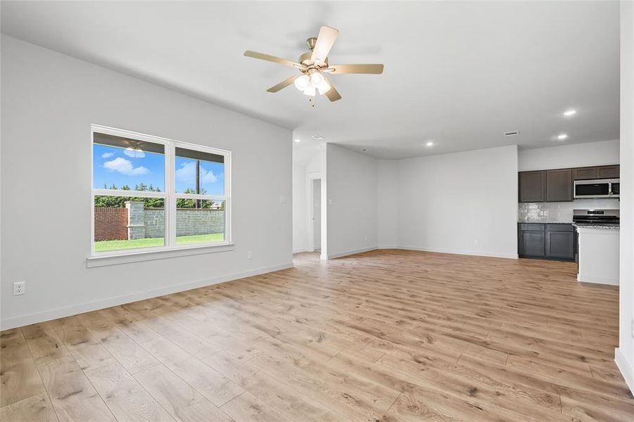 Unfurnished living room with light wood-style flooring, ceiling fan, and recessed lighting