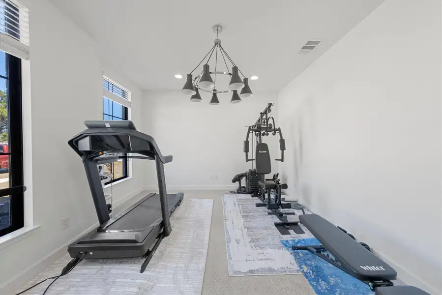 Workout area with baseboards, recessed lighting, visible vents, and a notable chandelier