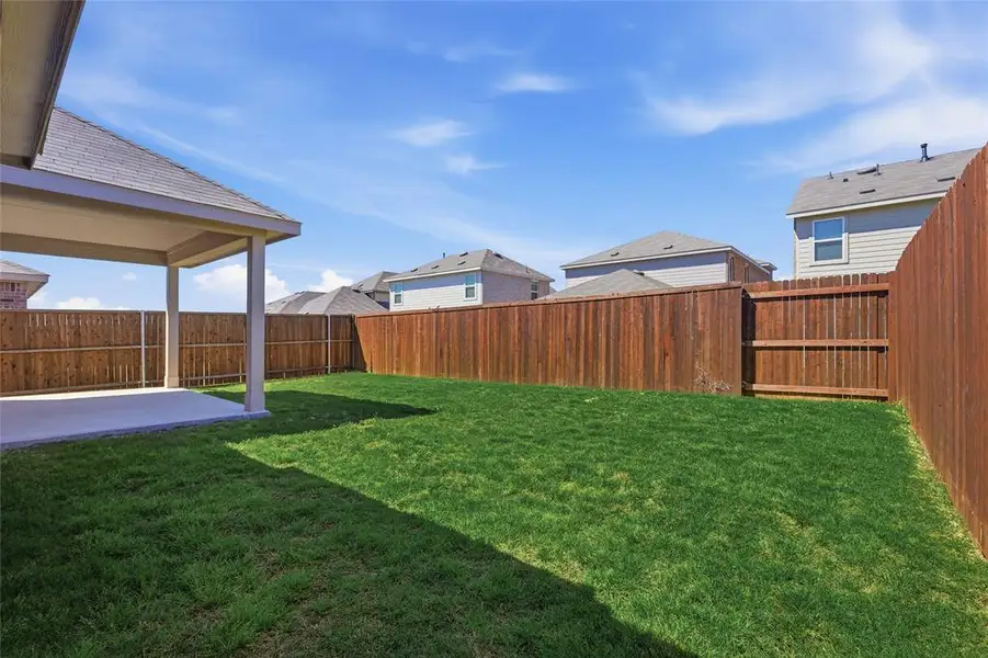 Fenced backyard with a patio