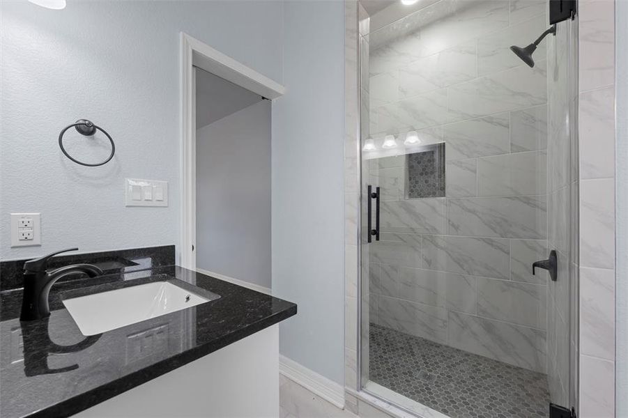 Full bathroom featuring a shower stall and vanity