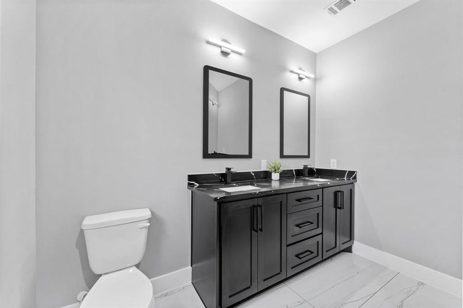 Luxurious primary bath with double sinks, stylish countertops, and modern fixtures.