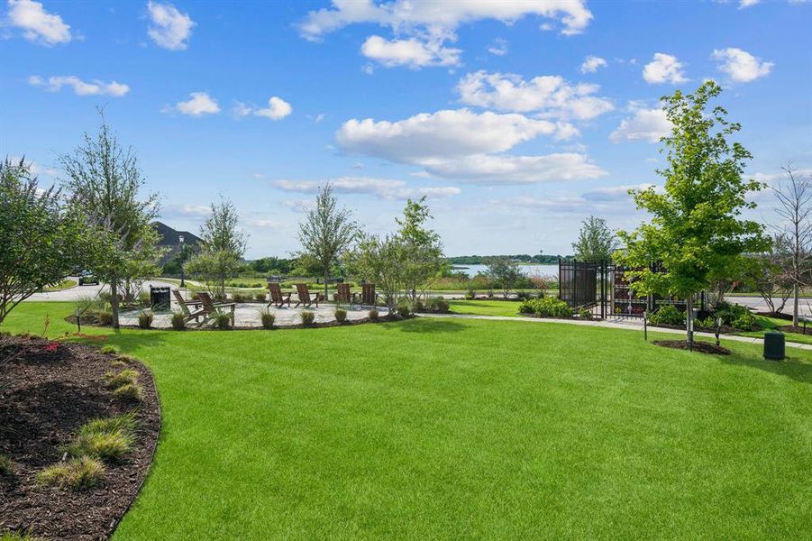 Expansive community green space featuring a circular paver patio with seating